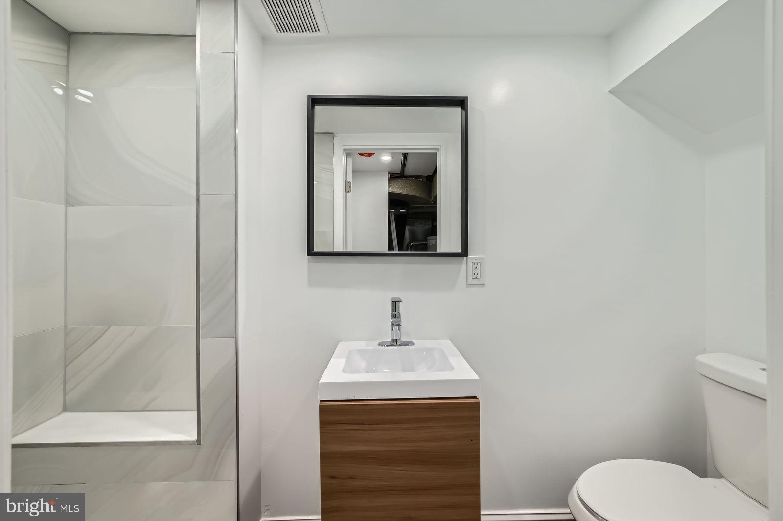 6200 Falkirk Road Baltimore, MD 21239 - Photo 24 of 27 a bathroom with a toilet sink and mirror