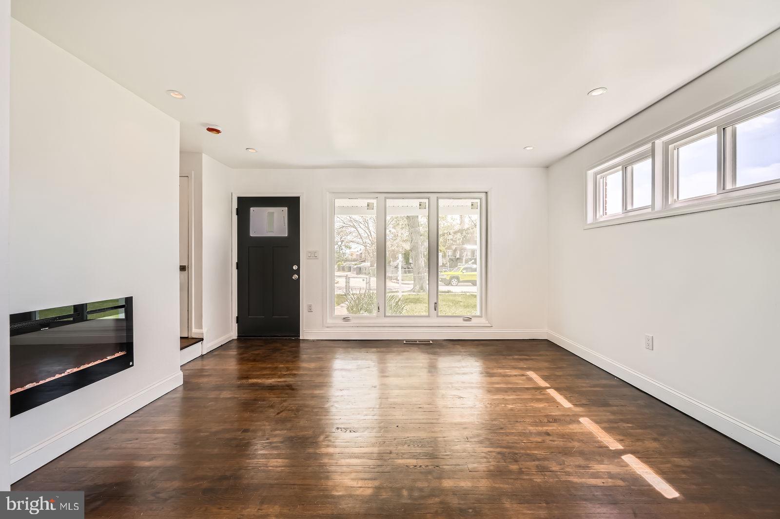 6200 Falkirk Road Baltimore, MD 21239 - Photo 6 of 27 a view of an empty room with a window and wooden floor