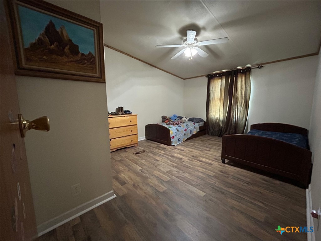 850 Blakely Road Gatesville, TX 76528 - Photo 27 of 32 a bedroom with a bed and wooden floor