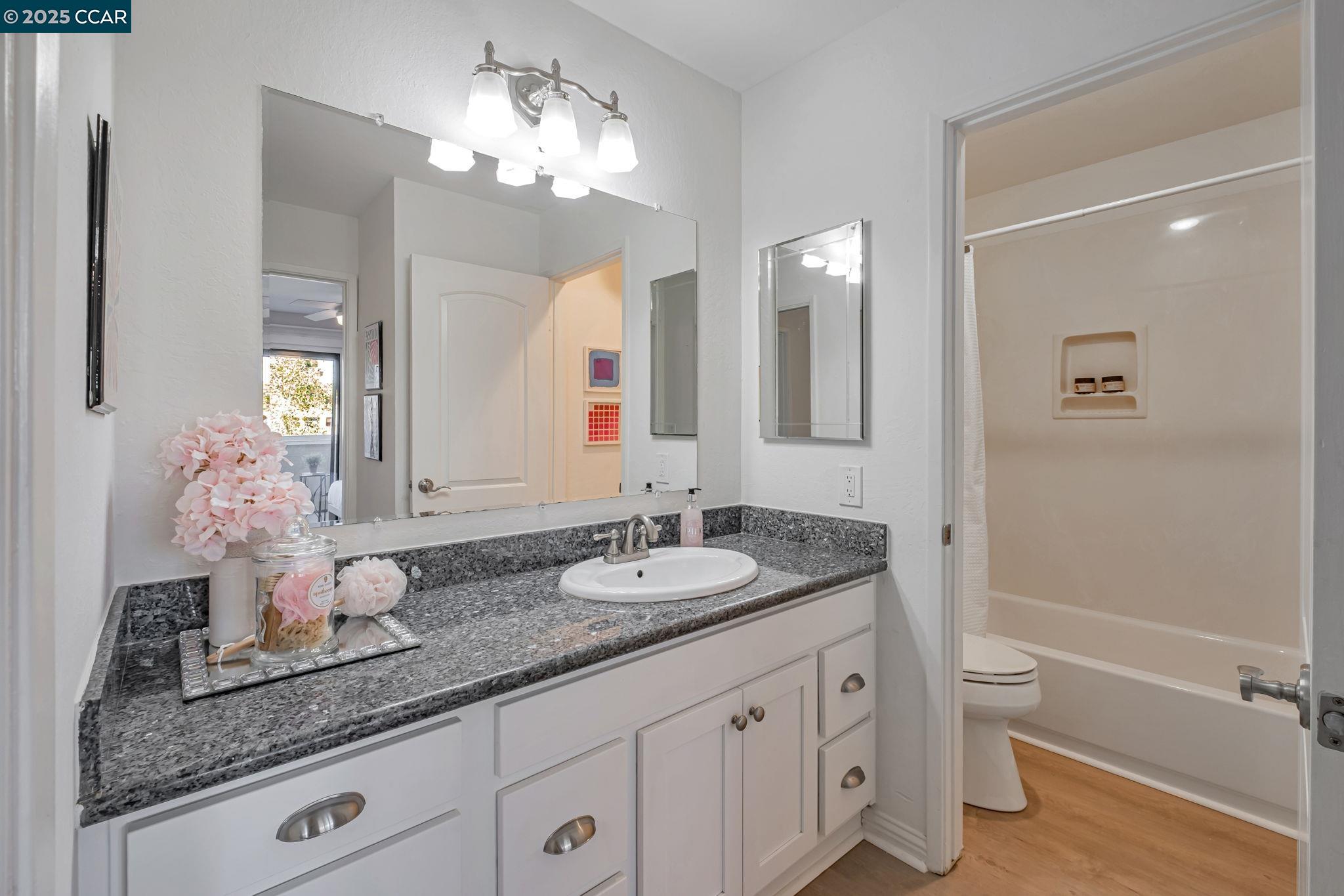 849 Tampico Walnut Creek, CA 94598 - Photo 14 of 24 a bathroom with a granite countertop sink a toilet and a mirror
