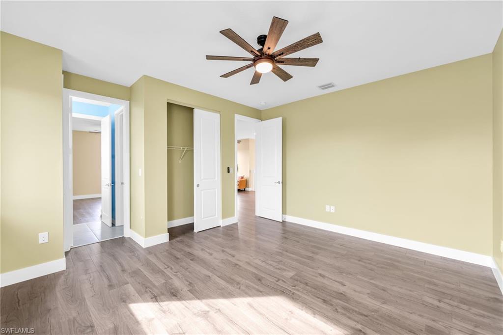 5074 Panella Avenue Immokalee, FL 34142 - Photo 22 of 48 a view of an empty room with wooden floor and a ceiling fan