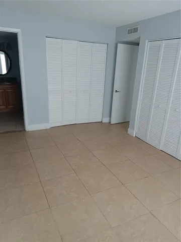 a bathroom with a granite countertop toilet sink and mirror