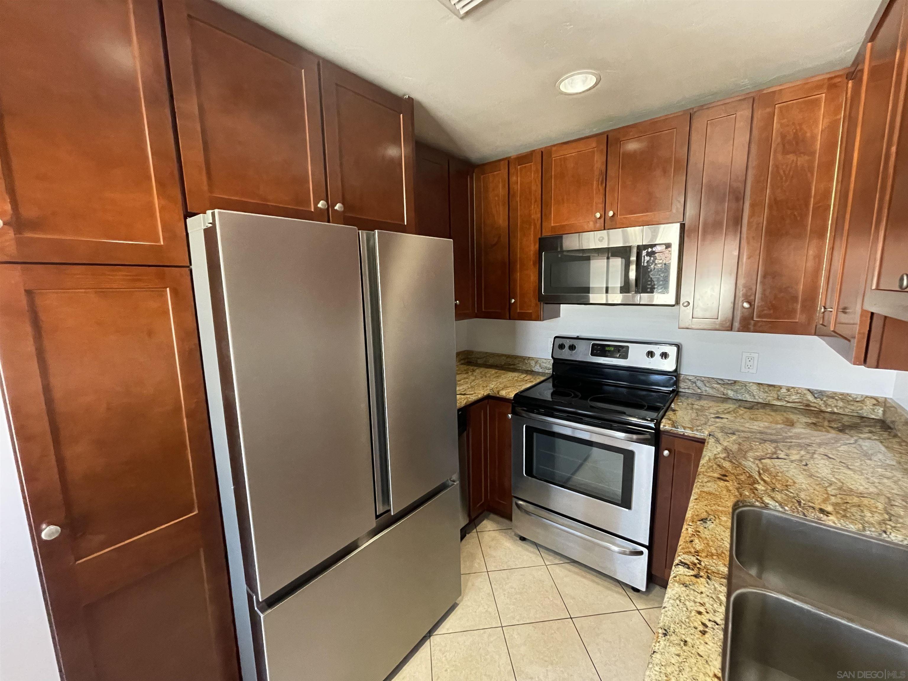 a kitchen with metallic refrigerator sink and microwave