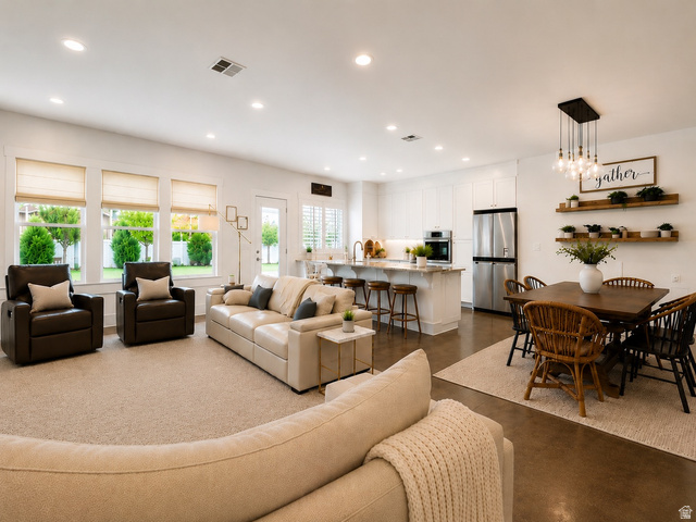 283 South Buffalo Ranch Road Farmington, UT 84025 - Photo 2 of 10 Open-concept living space featuring a carpeted living area, a dining area and a kitchen with stainless steel appliances