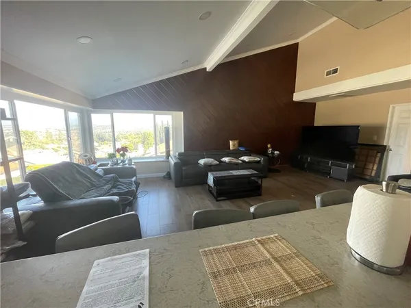 a living room with furniture a large window and a flat screen tv