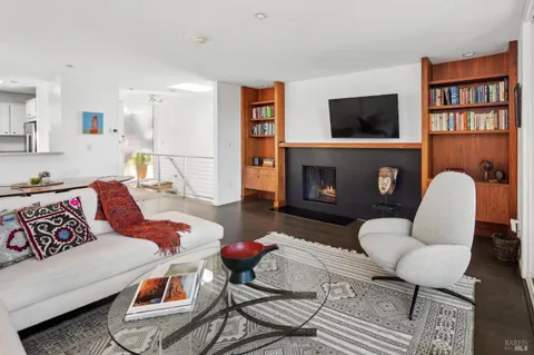 a living room with furniture a flat screen tv and a fireplace