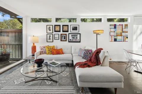 a living room with furniture a bookshelf and a wooden floor