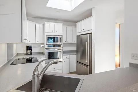 a kitchen with a refrigerator stove and white cabinets