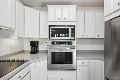a kitchen with cabinets stainless steel appliances and a sink