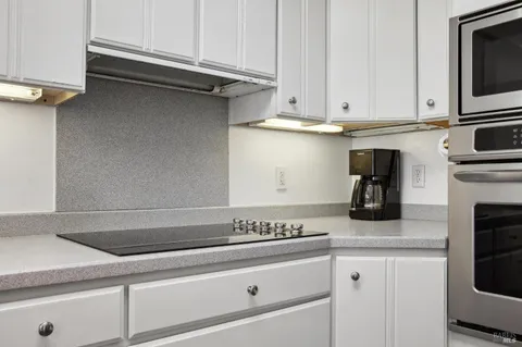 a kitchen with granite countertop cabinets stainless steel appliances and a sink