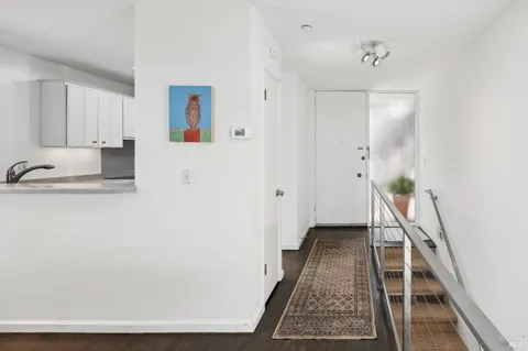 a view of a hallway with wooden floor and staircase