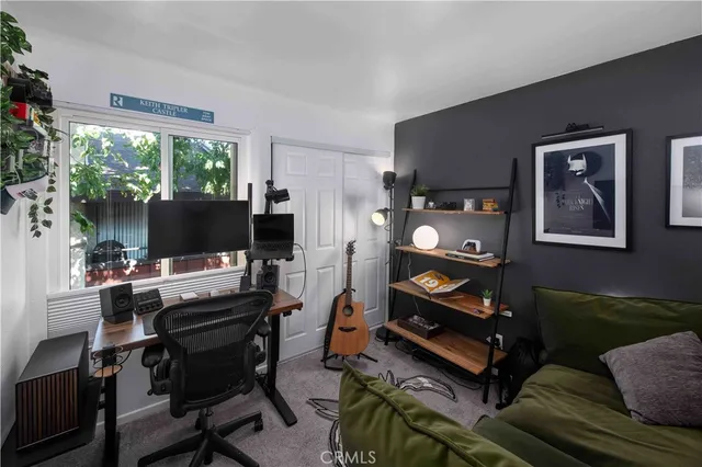 a living room with furniture a flat screen tv and a floor to ceiling window