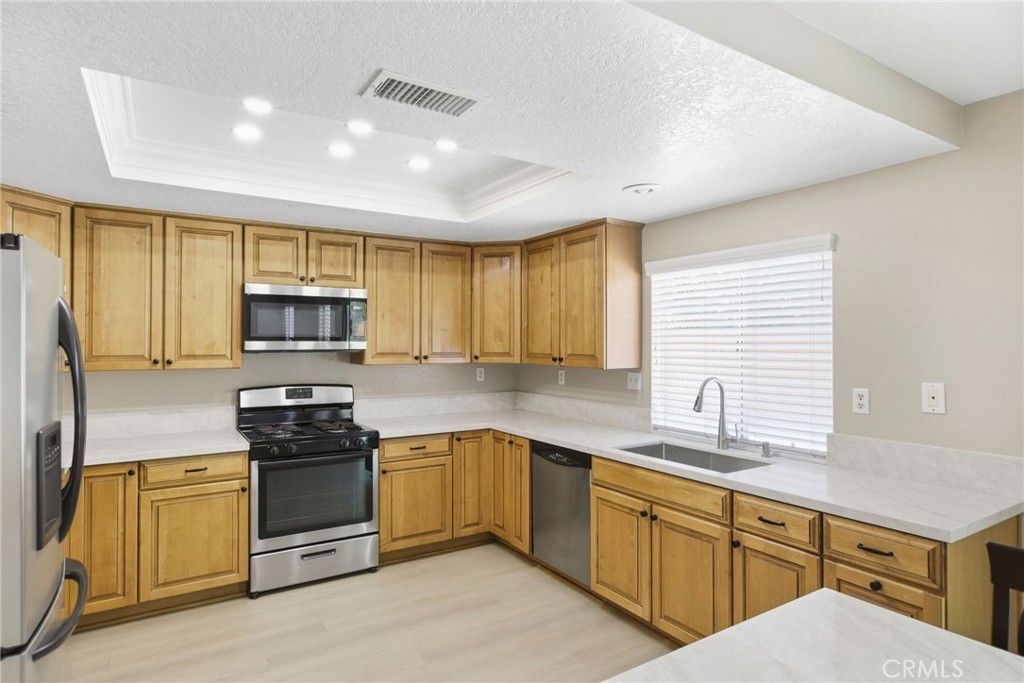 24333 Rimcrest Lane Moreno Valley, CA 92557 - Photo 18 of 62 a kitchen with stainless steel appliances granite countertop a sink stove refrigerator and cabinets