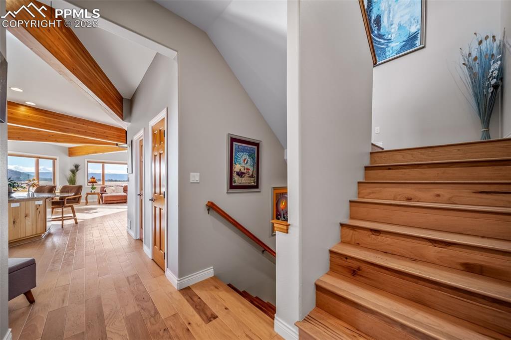 4586 East Best Road Larkspur, CO 80118 - Photo 19 of 50 Staircase featuring beam ceiling, wood-type flooring, and recessed lighting