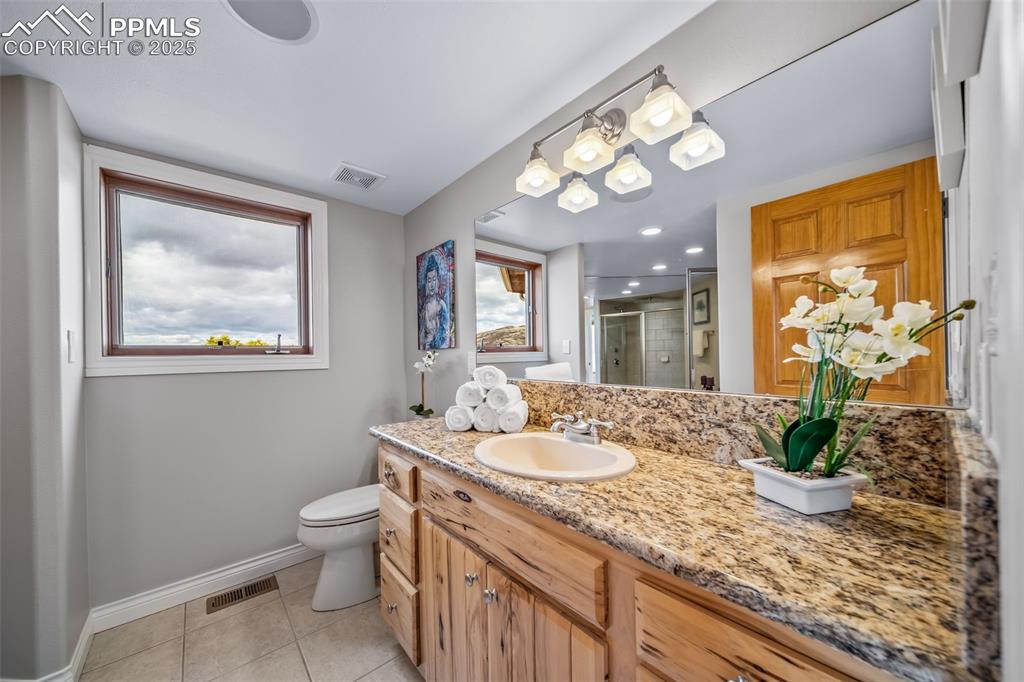 4586 East Best Road Larkspur, CO 80118 - Photo 26 of 50 Bathroom featuring vanity, a shower stall, light tile patterned floors, and plenty of natural light