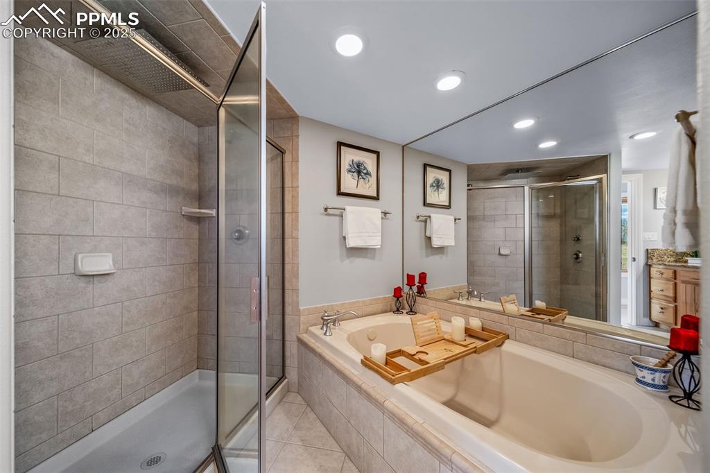 4586 East Best Road Larkspur, CO 80118 - Photo 27 of 50 Full bath featuring a shower stall, vanity, a garden tub, light tile patterned floors, and recessed lighting