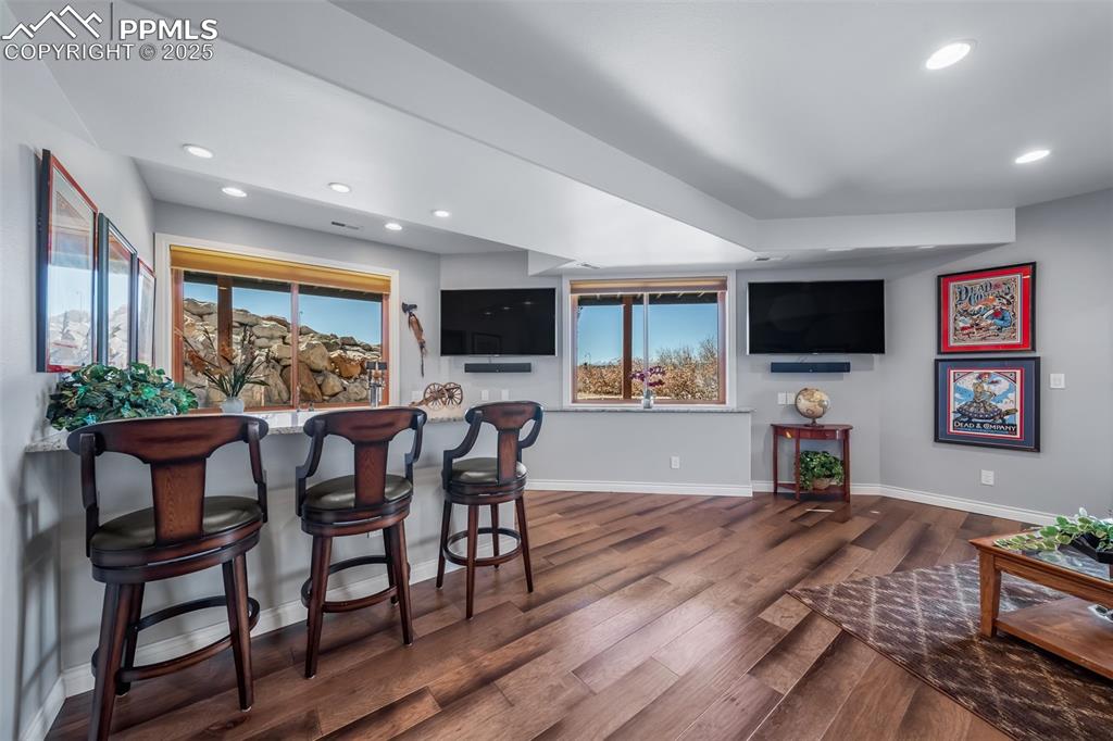 4586 East Best Road Larkspur, CO 80118 - Photo 28 of 50 Bar area featuring recessed lighting, dark wood finished floors, and light stone counters
