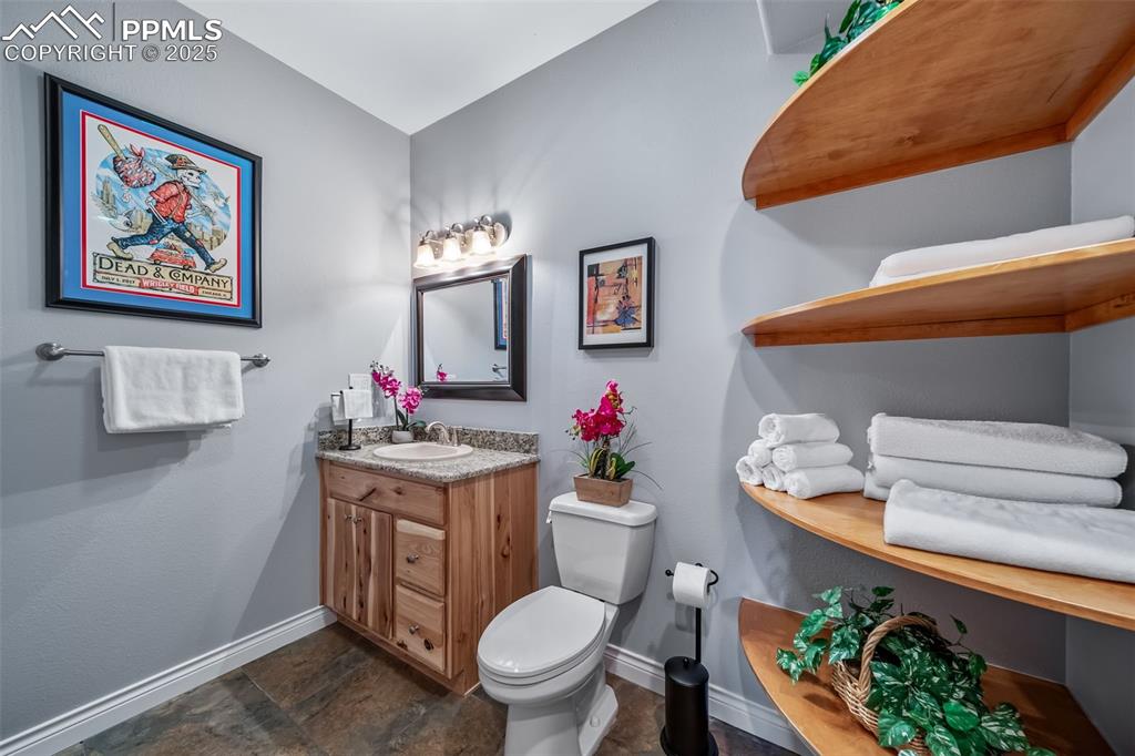 4586 East Best Road Larkspur, CO 80118 - Photo 35 of 50 Bathroom featuring vanity and dark stone finish flooring