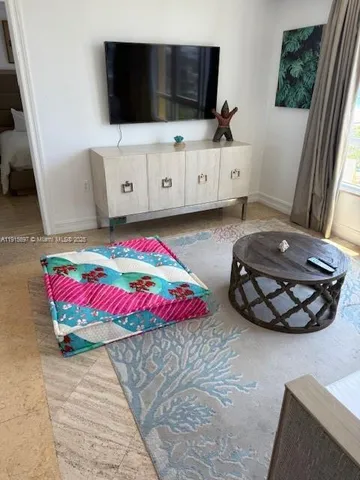 a living room with a bed furniture and a flat screen tv