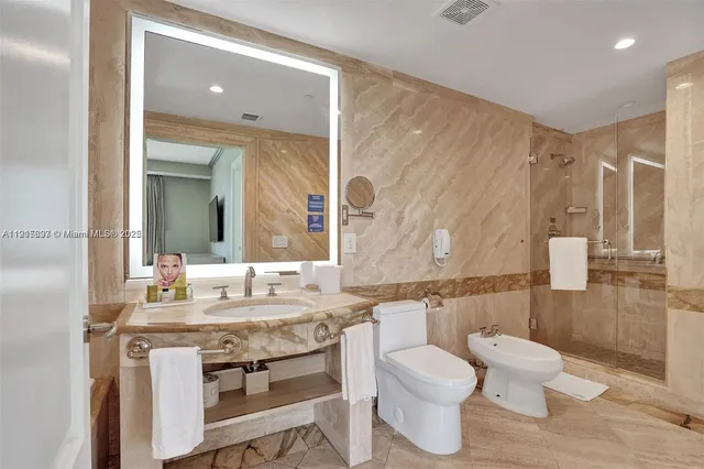 a bathroom with a granite countertop toilet sink and mirror