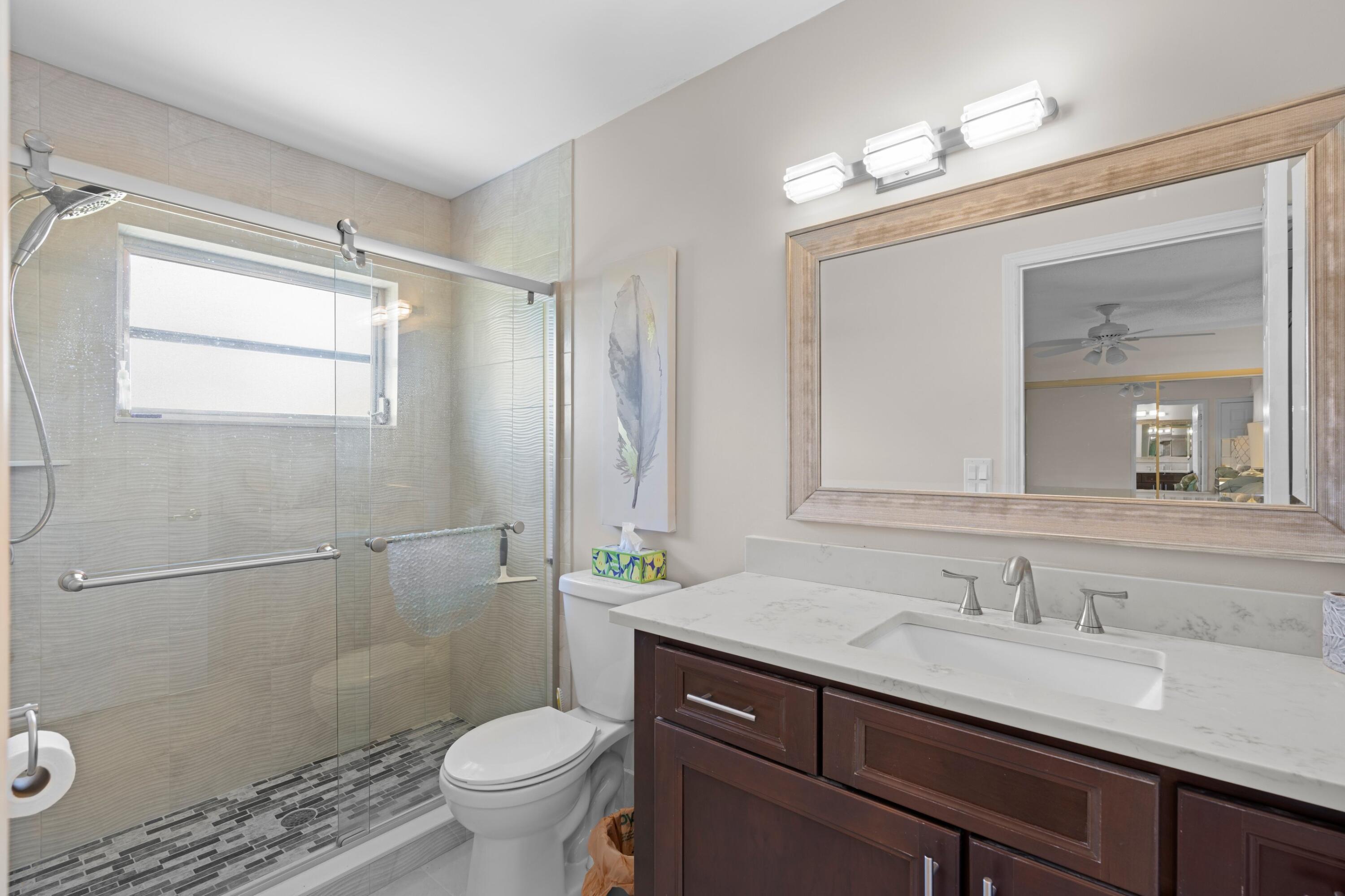 14609 Canalview Drive, Unit 231A Delray Beach, FL 33484 - Photo 11 of 33 a bathroom with a granite countertop sink toilet and shower