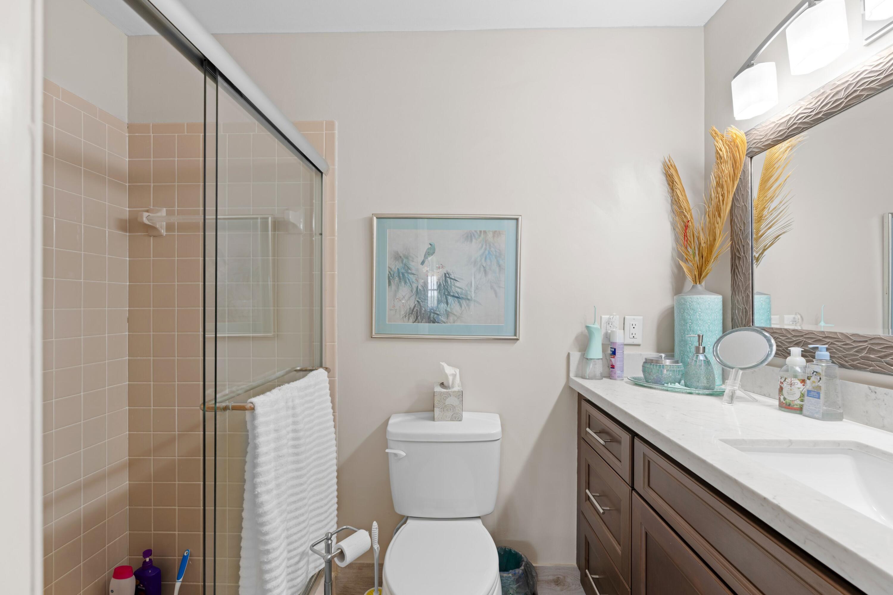 14609 Canalview Drive, Unit 231A Delray Beach, FL 33484 - Photo 13 of 33 a bathroom with a sink a toilet and a mirror