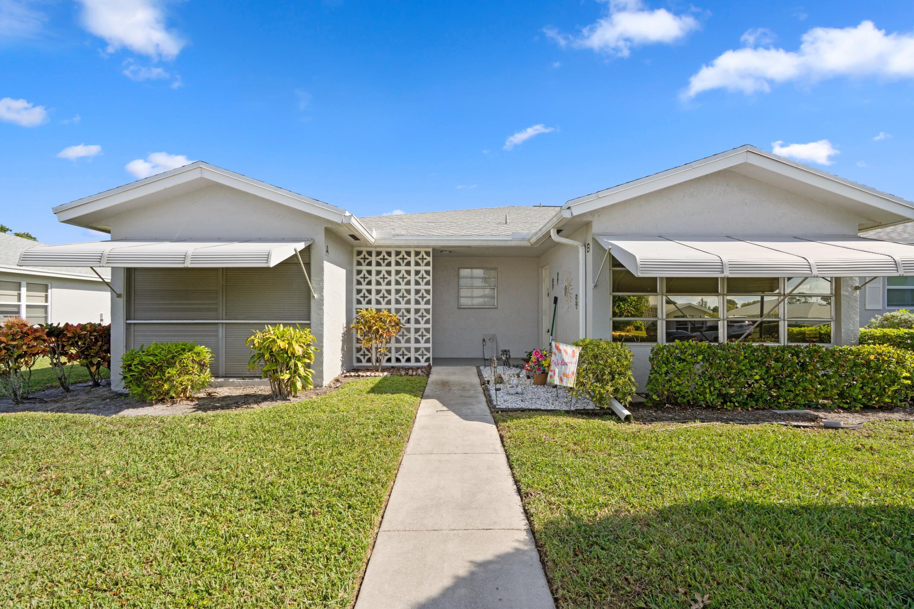 14609 Canalview Drive, Unit 231A Delray Beach, FL 33484 - Photo 2 of 33 a front view of a house with a yard outdoor seating and mountain view