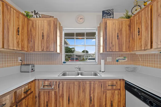 a kitchen with stainless steel appliances wooden cabinets a sink and a window