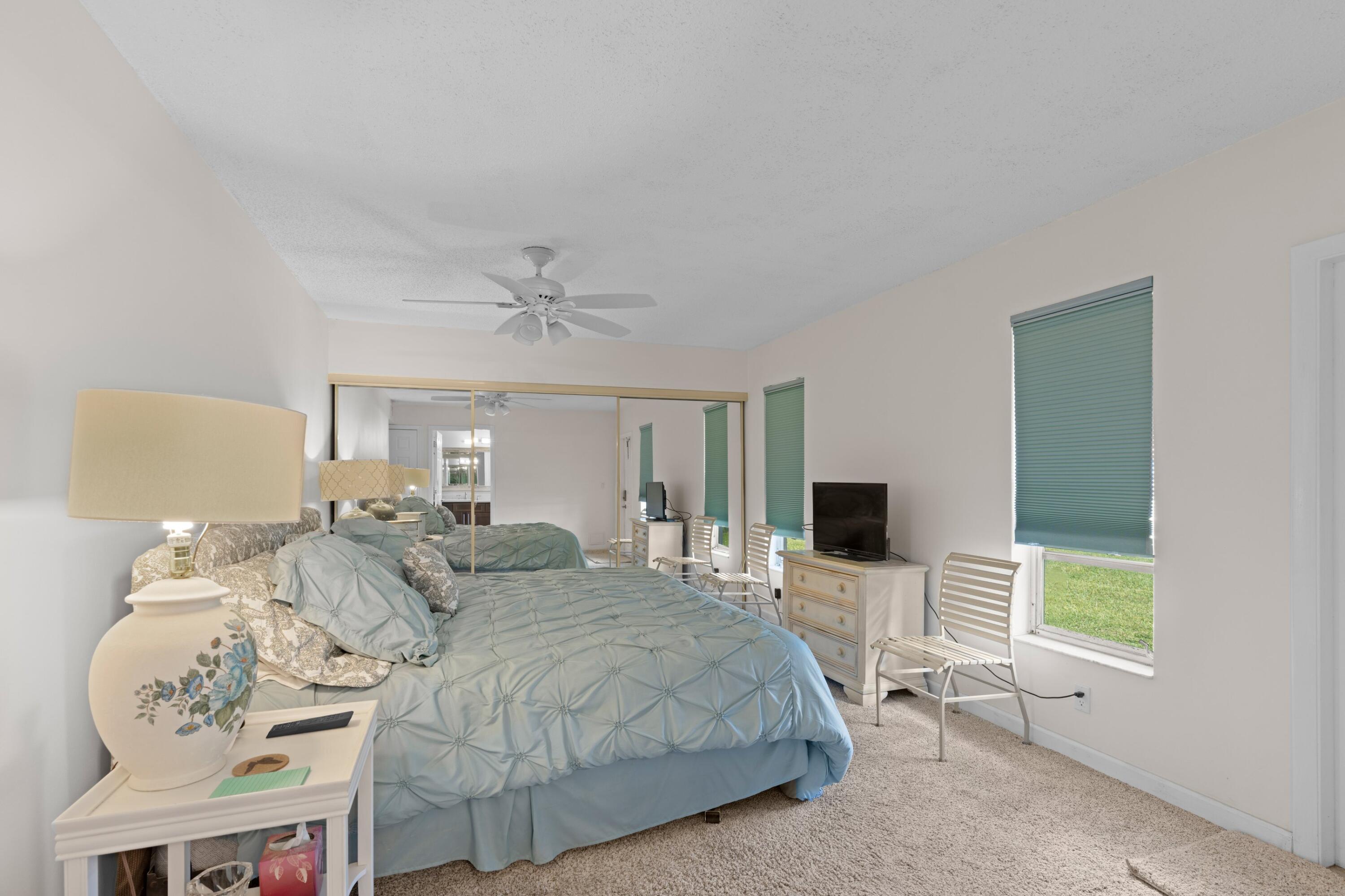 14609 Canalview Drive, Unit 231A Delray Beach, FL 33484 - Photo 10 of 33 a spacious bedroom with a bed and flat screen tv