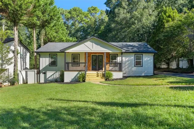 a front view of a house with a yard porch and wooden fence