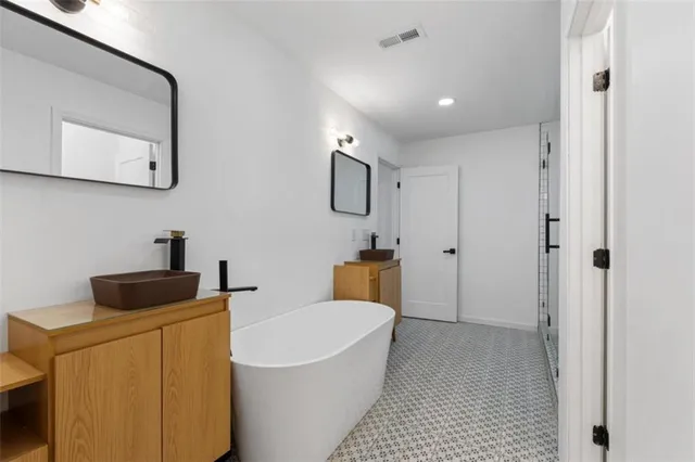 a bathroom with a tub sink and mirror