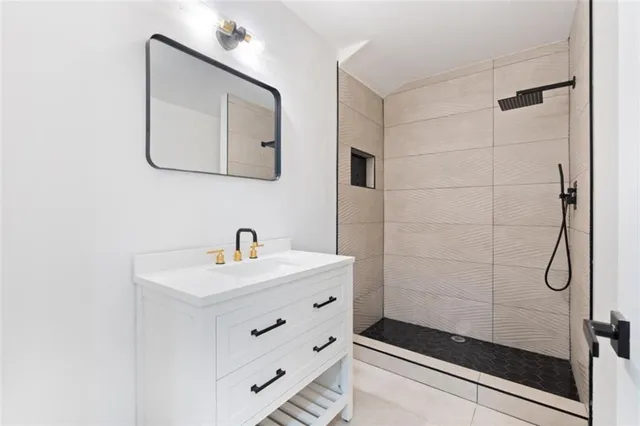 a bathroom with a sink a mirror a vanity and shower