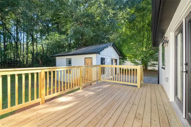 a view of a wooden deck and a yard with wooden fence