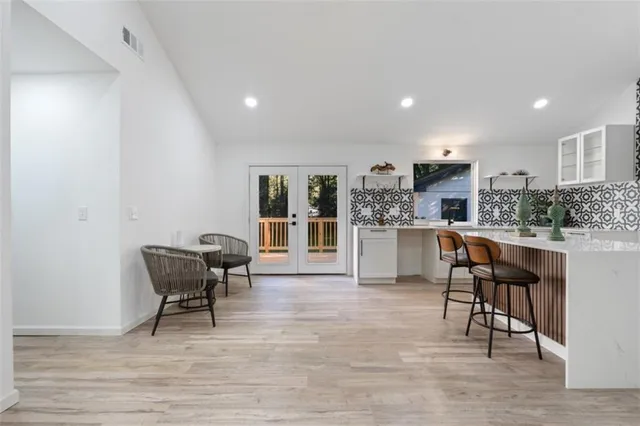 a living room with stainless steel appliances kitchen island granite countertop furniture wooden floor and a kitchen view