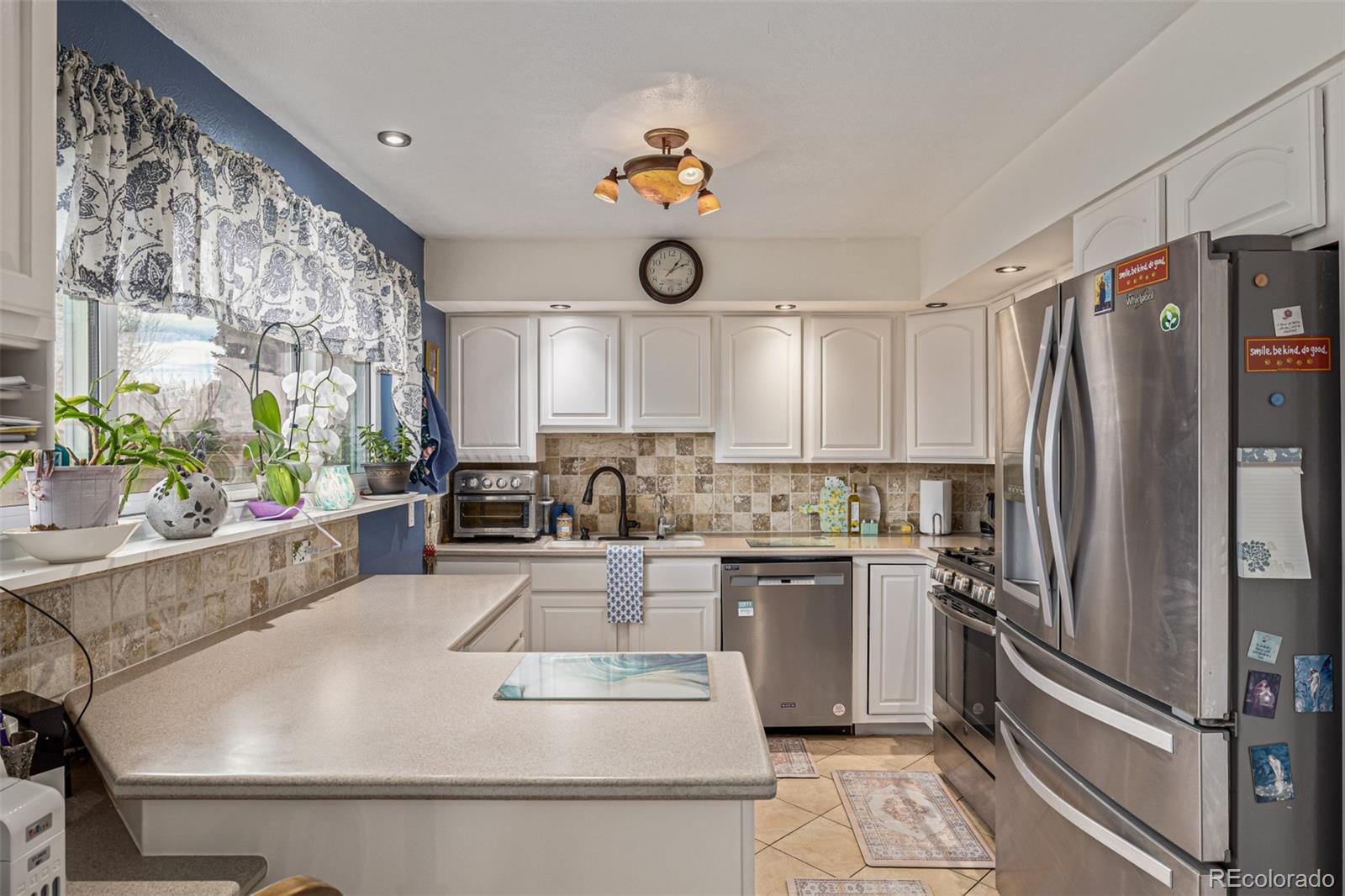 4233 East Maplewood Way Centennial, CO 80121 - Photo 11 of 50 a kitchen with stainless steel appliances granite countertop a refrigerator a stove a sink dishwasher and white cabinets with wooden floor