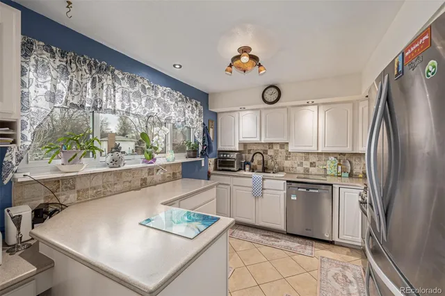 a kitchen with kitchen island a stove a sink and a refrigerator