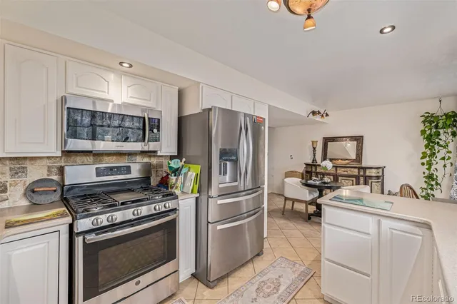 a kitchen with a stove refrigerator and microwave