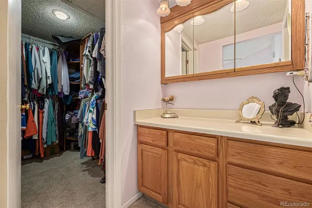 a view of walk in closet with clothes