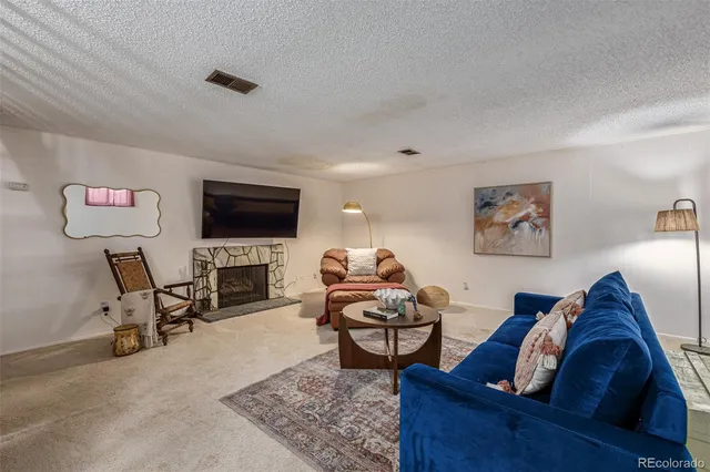 a living room with furniture and a flat screen tv with kitchen view