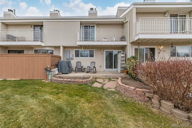 a view of a house with backyard and sitting area