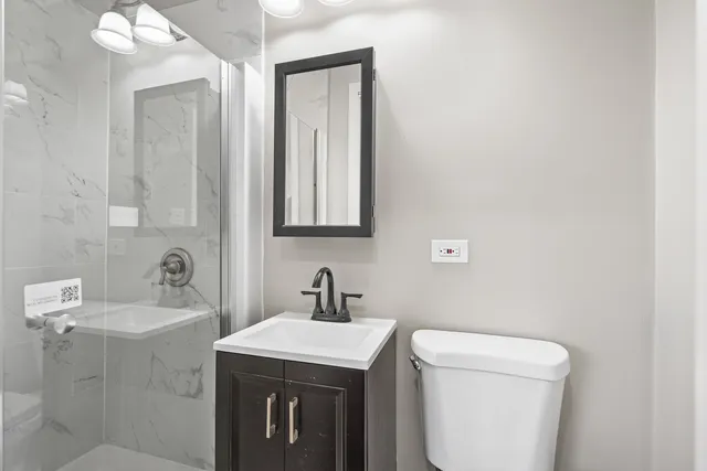 a bathroom with a toilet sink and mirror