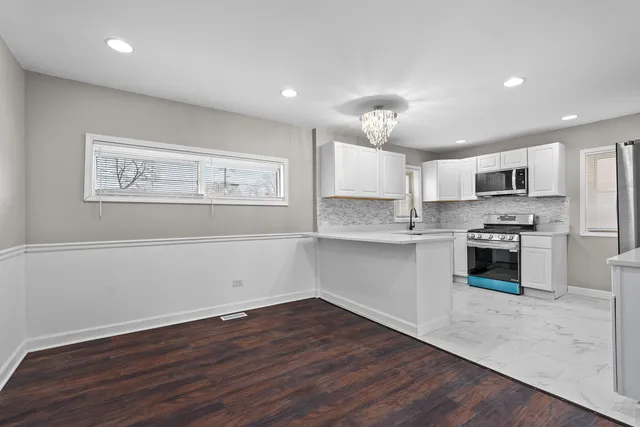 a kitchen with a refrigerator and a stove top oven