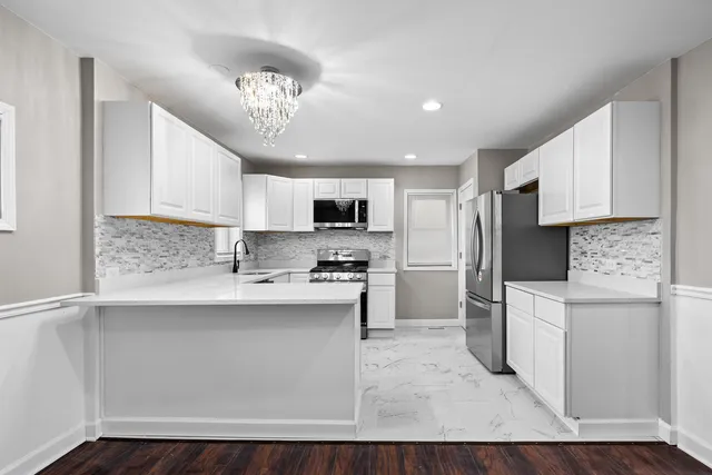 a kitchen with stainless steel appliances granite countertop a refrigerator sink and stove