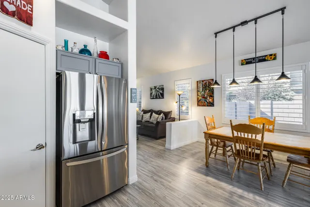 a kitchen with stainless steel appliances wooden floor and dining table