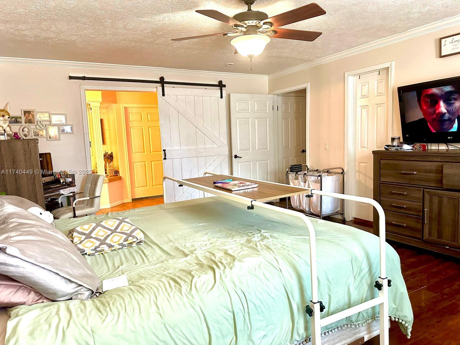 195 Southwest Turkey Glen Fort White, FL 32038 - Photo 18 of 25 a bed room with a bed television and a large window