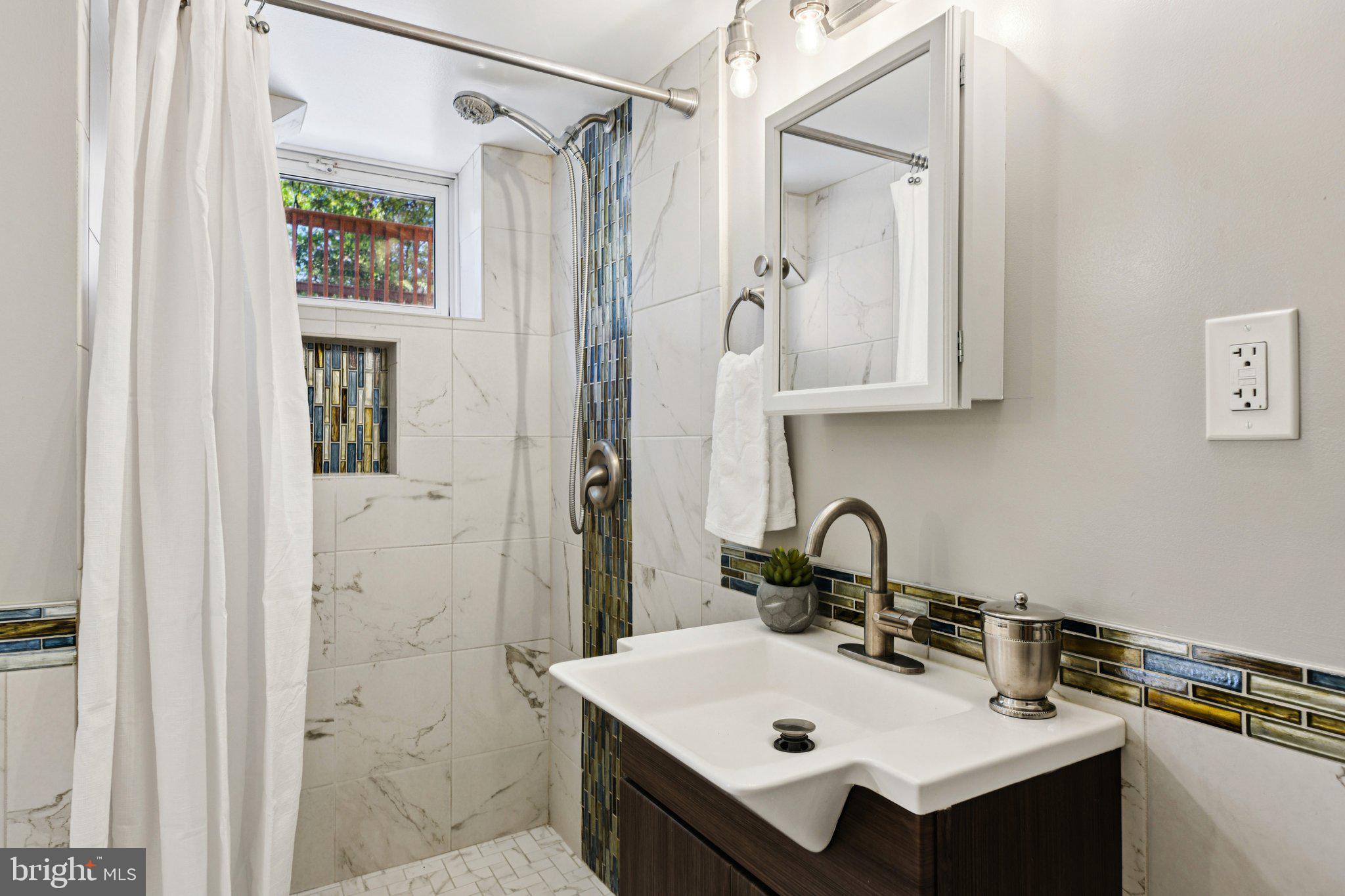 4012 Beechwood Road University Park, MD 20782 - Photo 39 of 56 a bathroom with a sink mirror and a shower