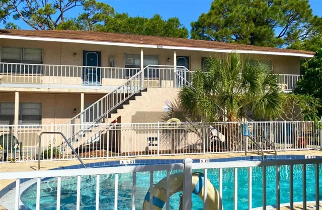 a view of a house with a small yard and wooden fence