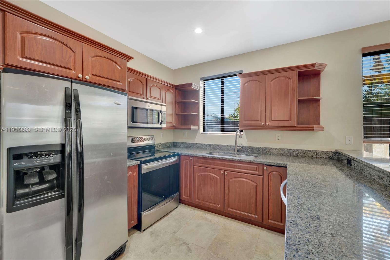 2654 Southwest 31st Place, Unit 2654 Miami, FL 33133 - Photo 4 of 17 a kitchen with stainless steel appliances granite countertop a refrigerator and a sink