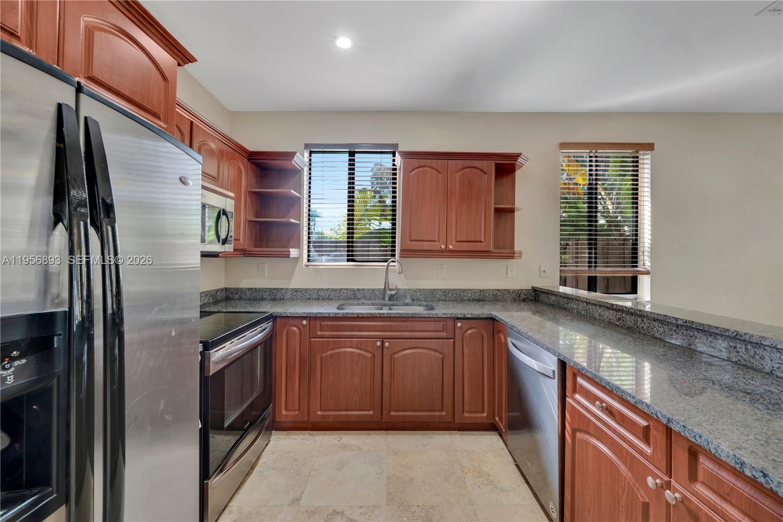 2654 Southwest 31st Place, Unit 2654 Miami, FL 33133 - Photo 5 of 17 a kitchen with stainless steel appliances granite countertop a sink stove and refrigerator