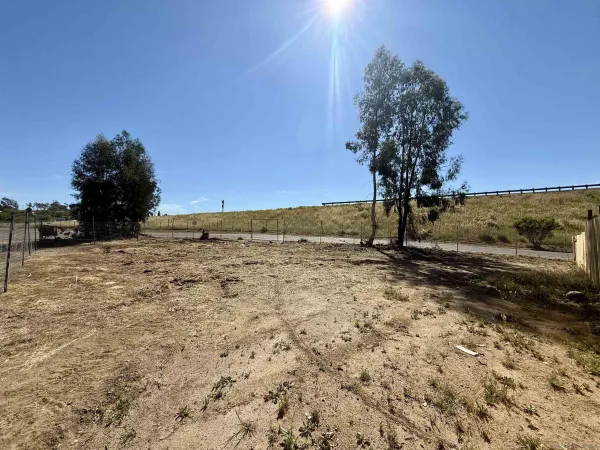 a view of a yard with wooden fence